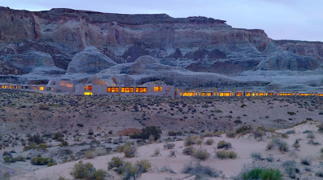 Amangiri at dusk, its lit windows low against the sandstone cliffs of the Utah desert