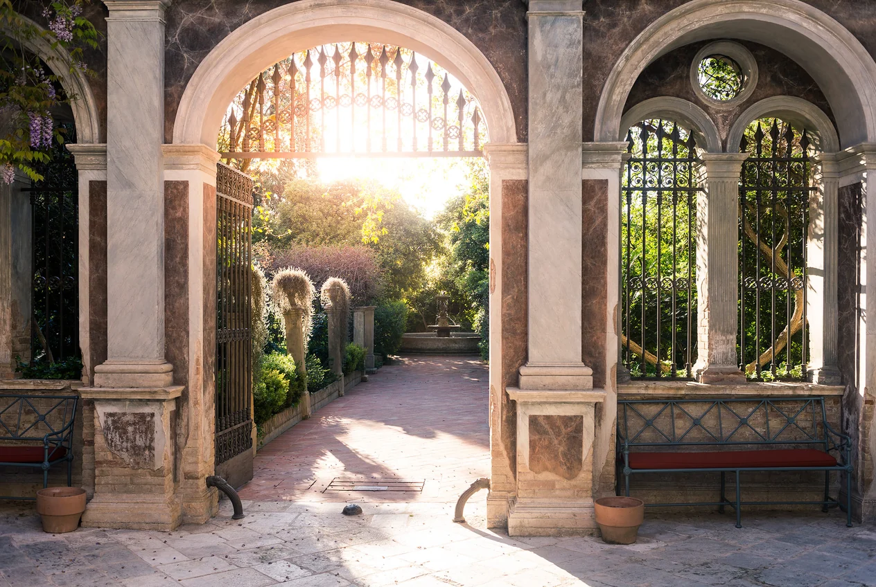 A sunlit stone loggia opening onto the walled garden at Palazzo Margherita